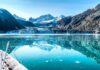 Boat approaching a glacier in a turquoise fjord