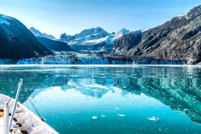 Boat approaching a glacier in a turquoise fjord