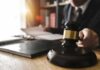 Illegal Power Grab? DOJ Plan Backfires Judge's gavel on desk with person reading documents in background
