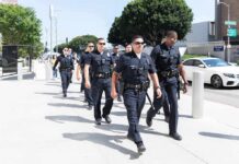 Police officers walking in formation on a city sidewalk