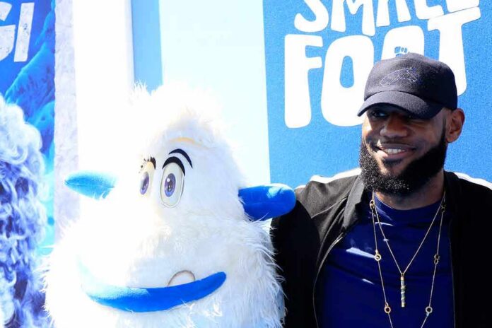 LeBron James posing next to a white yeti mascot at a blue-themed event
