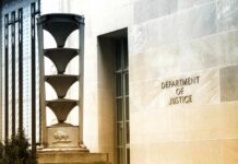 False Trafficking Claim Implodes – Apology Stuns Department of Justice building exterior with sign and metal sculpture