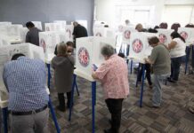 20,000 Red Flags – What Did California Miss? Voters fill out ballots at polling booths in a busy voting room