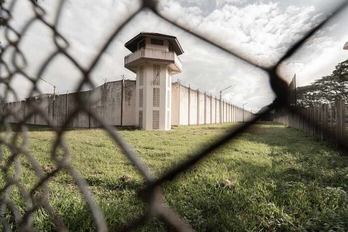 Prison watchtower behind chain-link fence