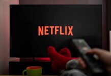 TV screen with Netflix logo and person holding remote