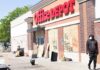 Shops Boarded Up – What Sparked This? Office supply store with boarded windows and graffiti