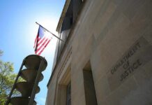 American flag on a pole outside a stone government building