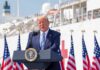 Pump Pain vs. Profit: Trump Lights Fuse Donald Trump speaking at a podium with American flags and a ship in the background